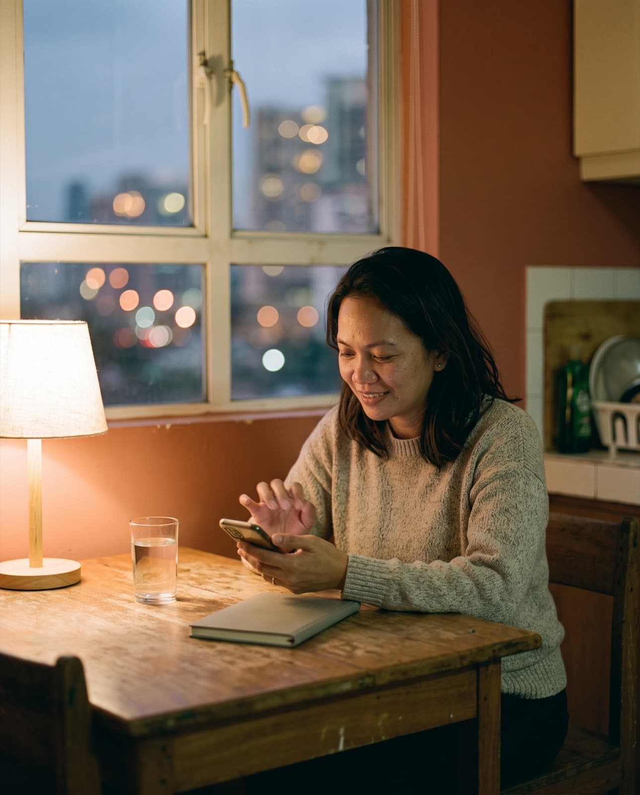 A tutor at home checking her phone after an online lesson